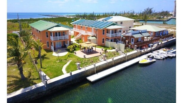 A coastal hotel with multiple buildings, a marina, and a view of the ocean.
