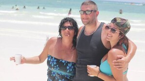 Eine Strandansicht mit Personen im Wasser und am Strand.