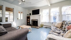A living room with a fireplace, a ceiling fan, and a television. - Four Night Min! Lakeside Home With 800 Feet Of Association Beach! (Lakeside)