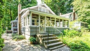 A house with a stone pathway leading to a porch with a metal railing. - Four Night Min! Lakeside Home With 800 Feet Of Association Beach! (Lakeside)