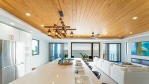 A modern kitchen with a large island, white cabinetry, and a view of the ocean. - 5 bed/4 bath Ocean side, right outside of Tavernier Creek Mile Marker 91 (Tavernier)