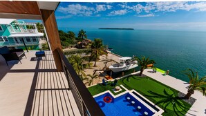 A balcony with a view of the sea, a swimming pool, and a small lawn area. - 5 bed/4 bath Ocean side, right outside of Tavernier Creek Mile Marker 91 (Tavernier)