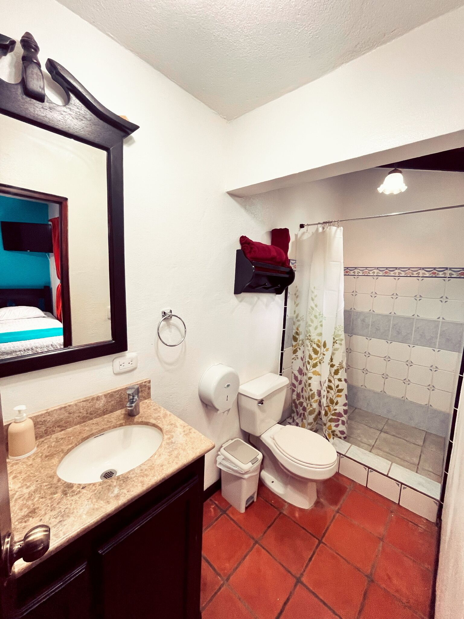 A bathroom with a sink, toilet, and shower.