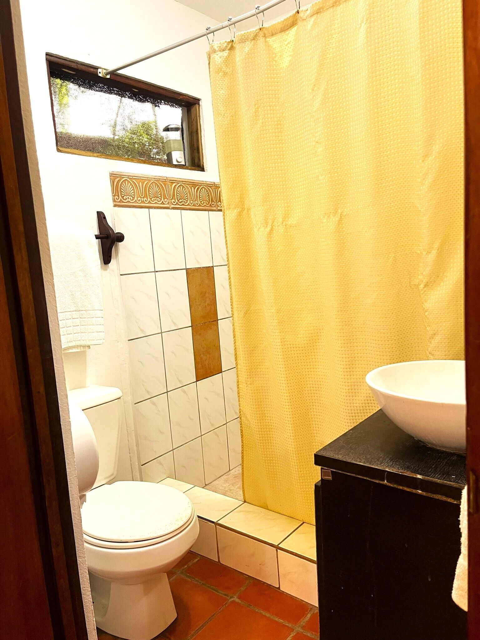 A bathroom with a toilet, a sink, and a shower curtain.