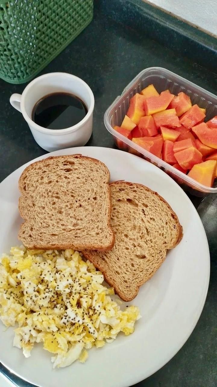 A breakfast plate with toast, scrambled eggs, and diced fruit.