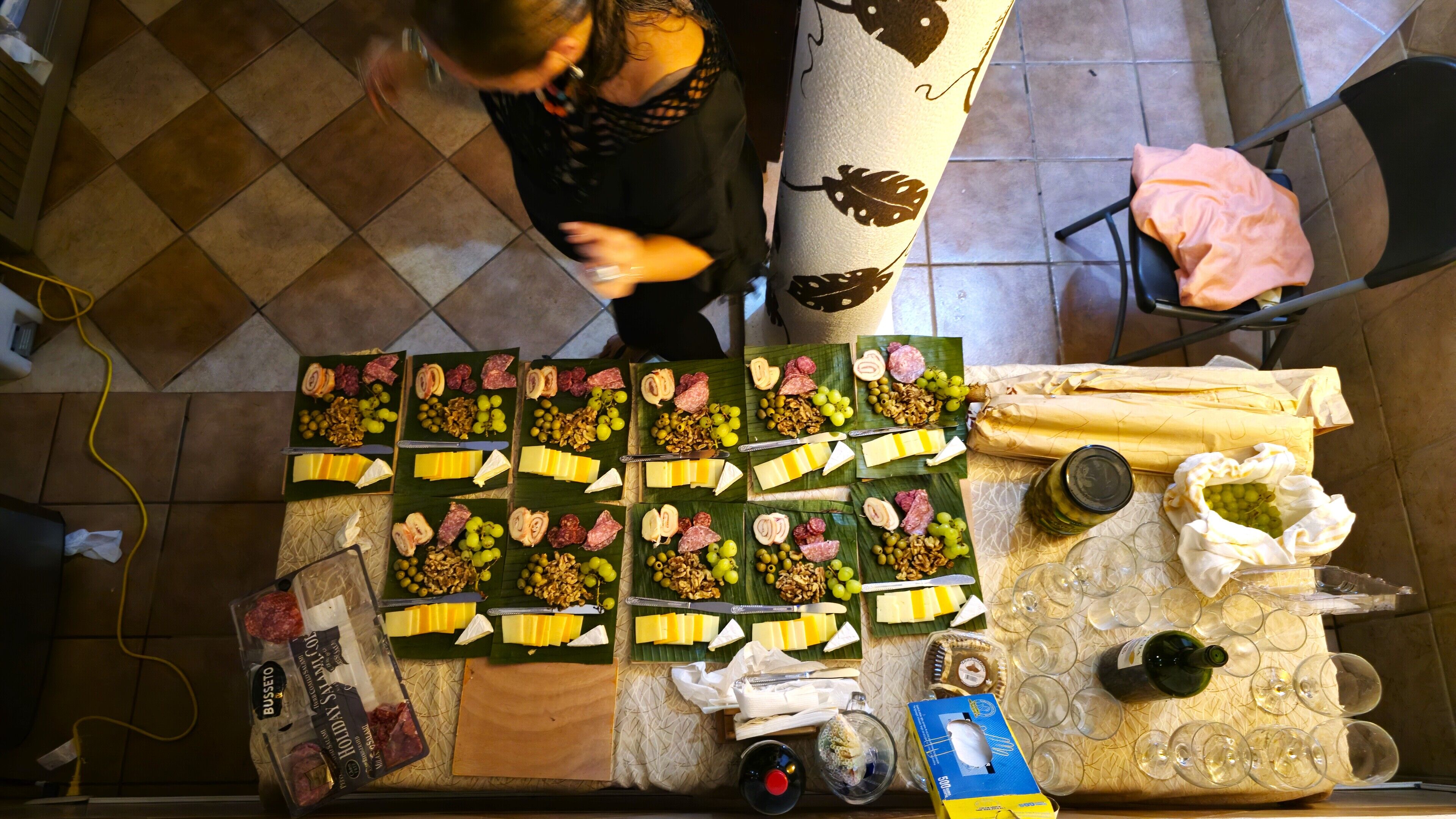 Una mesa con diferentes alimentos y una botella de vino, mostrando una disposición para comer.