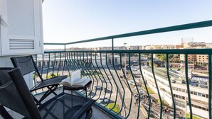 Un balcon donnant sur un paysage urbain, avec des bâtiments et une route.
