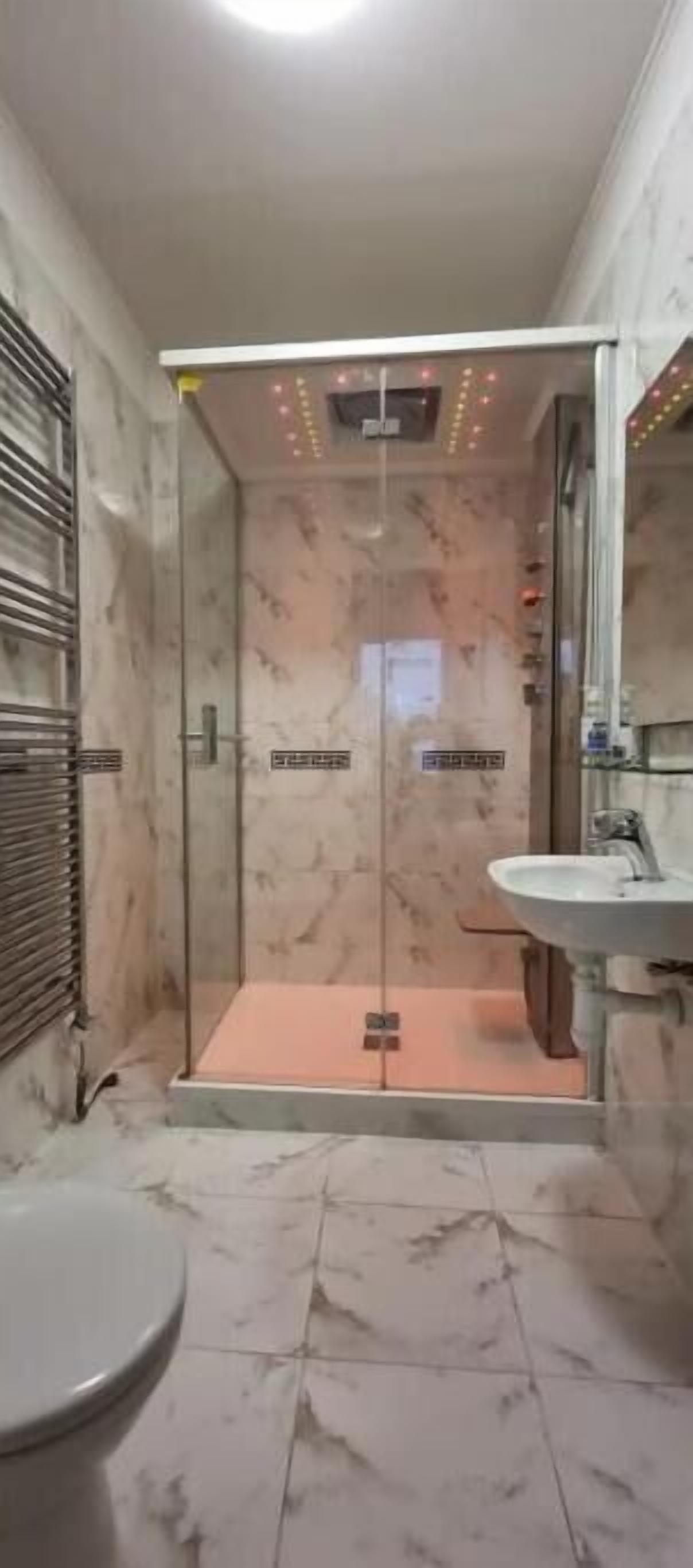 Ein Badezimmer mit Duschkabine, Waschbecken und Toilette.