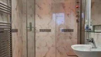Ein Badezimmer mit Duschkabine, Waschbecken und Toilette.