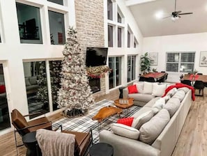Un salón amplio con un sofá blanco grande, una mesa de centro y un árbol de Navidad.