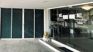 A building entrance with a glass door, a small statue, and a sign reading 'Homsin Apartment.' - Navanakorn Aomsin Hotel near Big C Super (Khlong Luang)