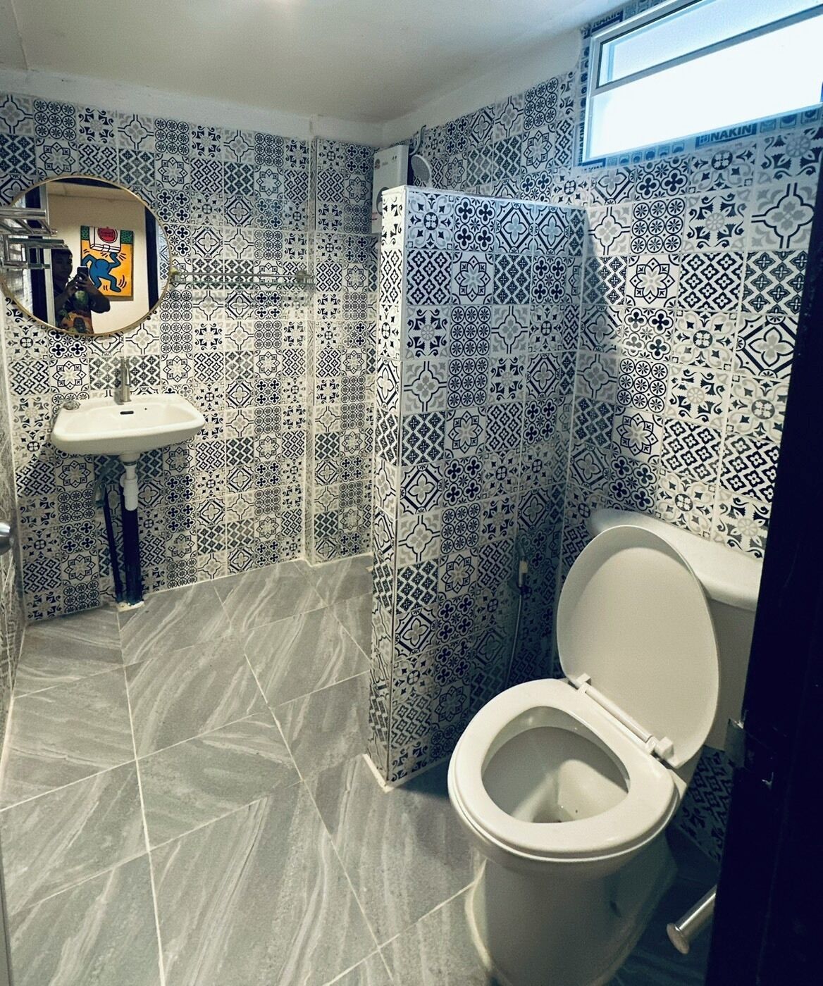 Un baño con baldosas estampadas, un lavamanos y un inodoro.
