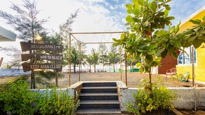 A set of stairs leading to a beach area with directional signs for a restaurant and beach access. - Treebo Salt Water Beach Resort (Dapoli)