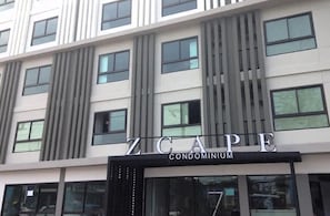 Ein modernes Gebäude mit dem Schriftzug "Z C A P E CONDOMINIUM" über dem Eingang.