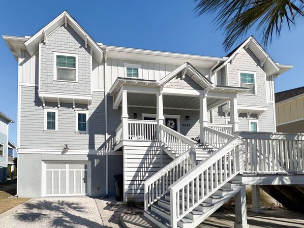 A two-story house with a front porch, a staircase, and a garage.