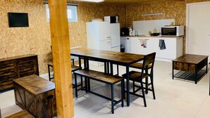 Et lille køkken med hvide skabe, en mikrobølgeovn og en kaffemaskine.