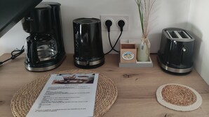 A kitchen counter with a coffee maker, toaster, and a vase with dried plants.