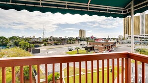 A balcony with a view of a cityscape, including buildings, a parking lot, and a road. - Panama City Beach Getaway - Walk to Beaches! (Panama City)
