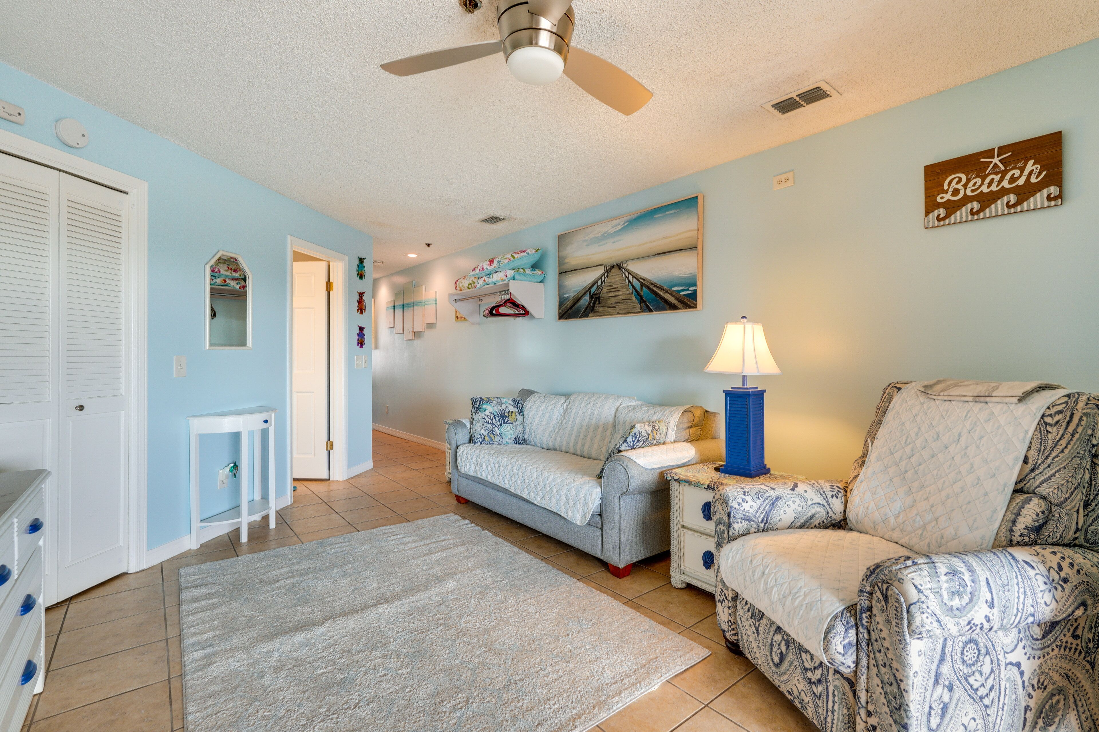 A living room with a sofa, a coffee table, a lamp, and a painting on the wall.