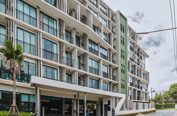 A multi-story hotel with a modern design, featuring balconies on each floor and a covered entrance area. - Zcape2 apartment by Lofty (Choeng Thale)