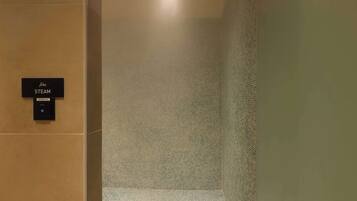A steam room with a sign indicating its name and a control panel.