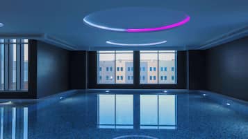 A spacious indoor area with a reflective floor, large windows, and modern circular ceiling lights.