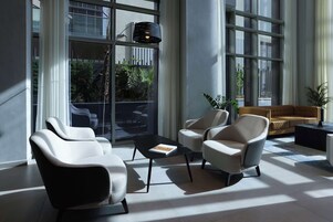 A modern lounge area with a sofa, two armchairs, and a coffee table.