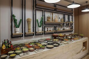 A buffet setup with various food items and condiments.
