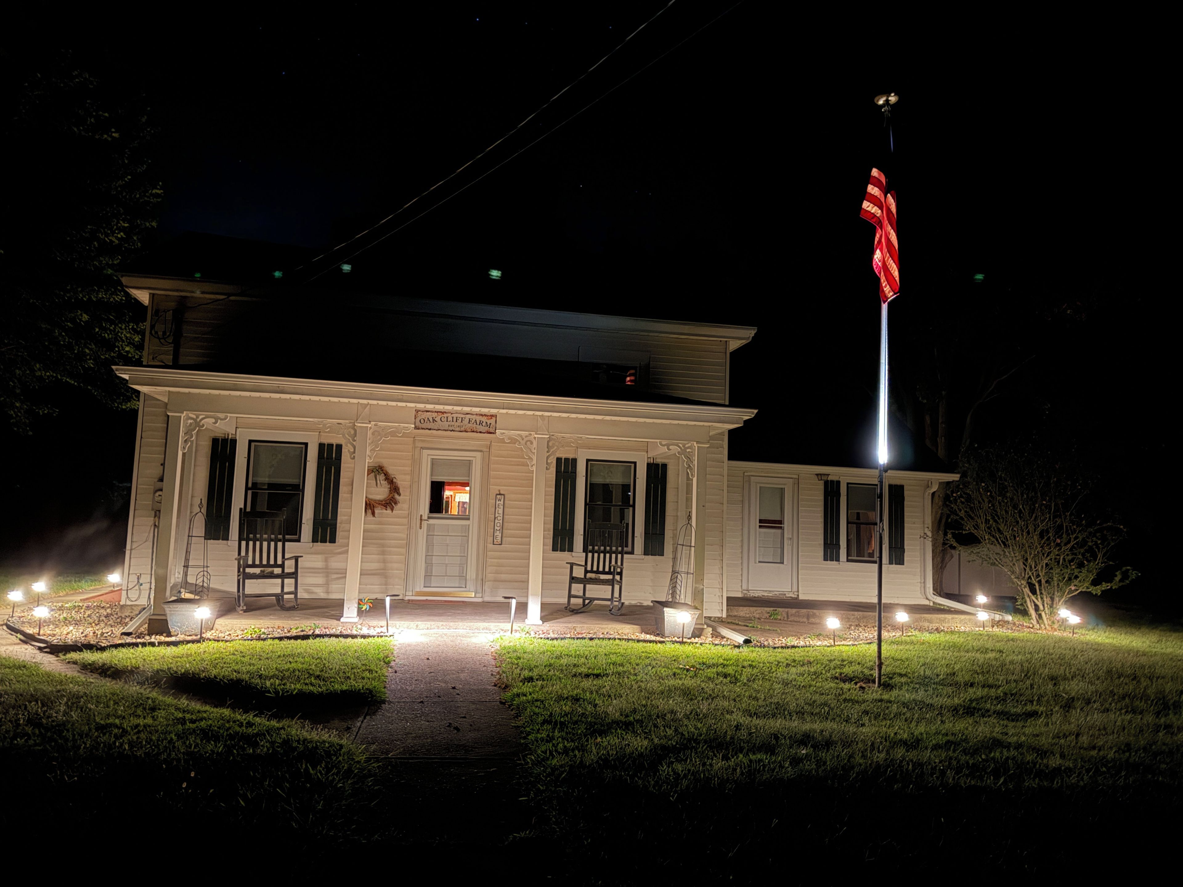 A two-story building with a porch and a flagpole.