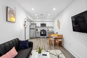 A modern apartment with a living room, dining area, and kitchen. - Stylish NW DC Unit with Balcony & In-House Services (Washington)
