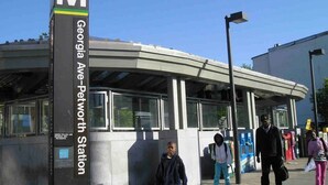 Ein modernes Gebäude mit einer gewölbten Dachkonstruktion und einem Schild, das anzeigt, dass dies die Georgia Ave-Petworth Station ist.