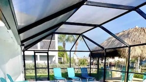 A covered swimming pool with blue chairs and a clear view of the surrounding area.