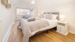 A bedroom with a bed, bedside table, and a window.