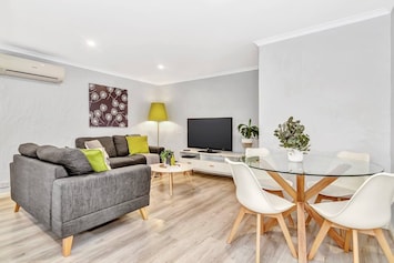 The living area features two 2-seater couches as well as a TV and DVD player.