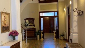 A hallway with a tiled floor, a wooden bench, a desk with a vase of flowers, and a framed picture on the wall. - Casa Ideal Para Familias, Amigos, Celebraciones. Estupenda Ubicación y Zona (Chella)
