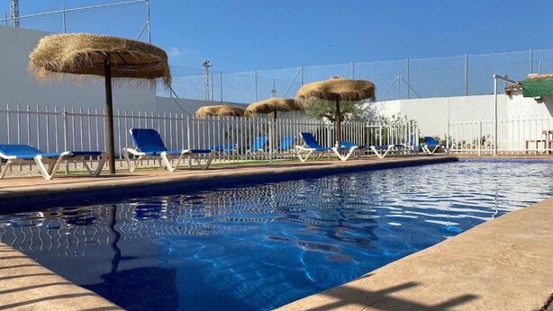 A swimming pool with blue water, surrounded by white fences, and blue lounge chairs. - Casa Ideal Para Familias, Amigos, Celebraciones. Estupenda Ubicación y Zona (Chella)