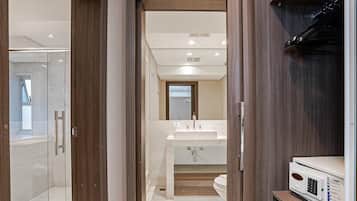 Eenvoudig appartement | Badkamer | Een douche, een haardroger, handdoeken, zeep