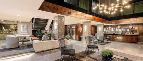 A spacious lobby with a reception desk, seating area, and a staircase.