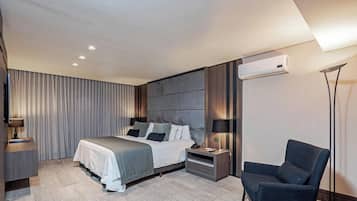 A modern hotel room with a bed, bedside tables, a chair, and an air conditioning unit.