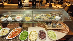A buffet with various dishes and a coffee machine.