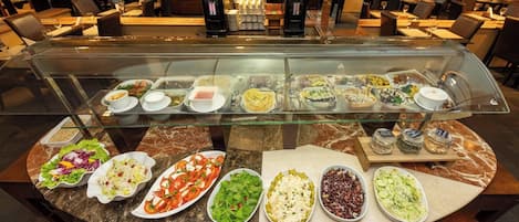 A buffet with various dishes and a coffee machine.