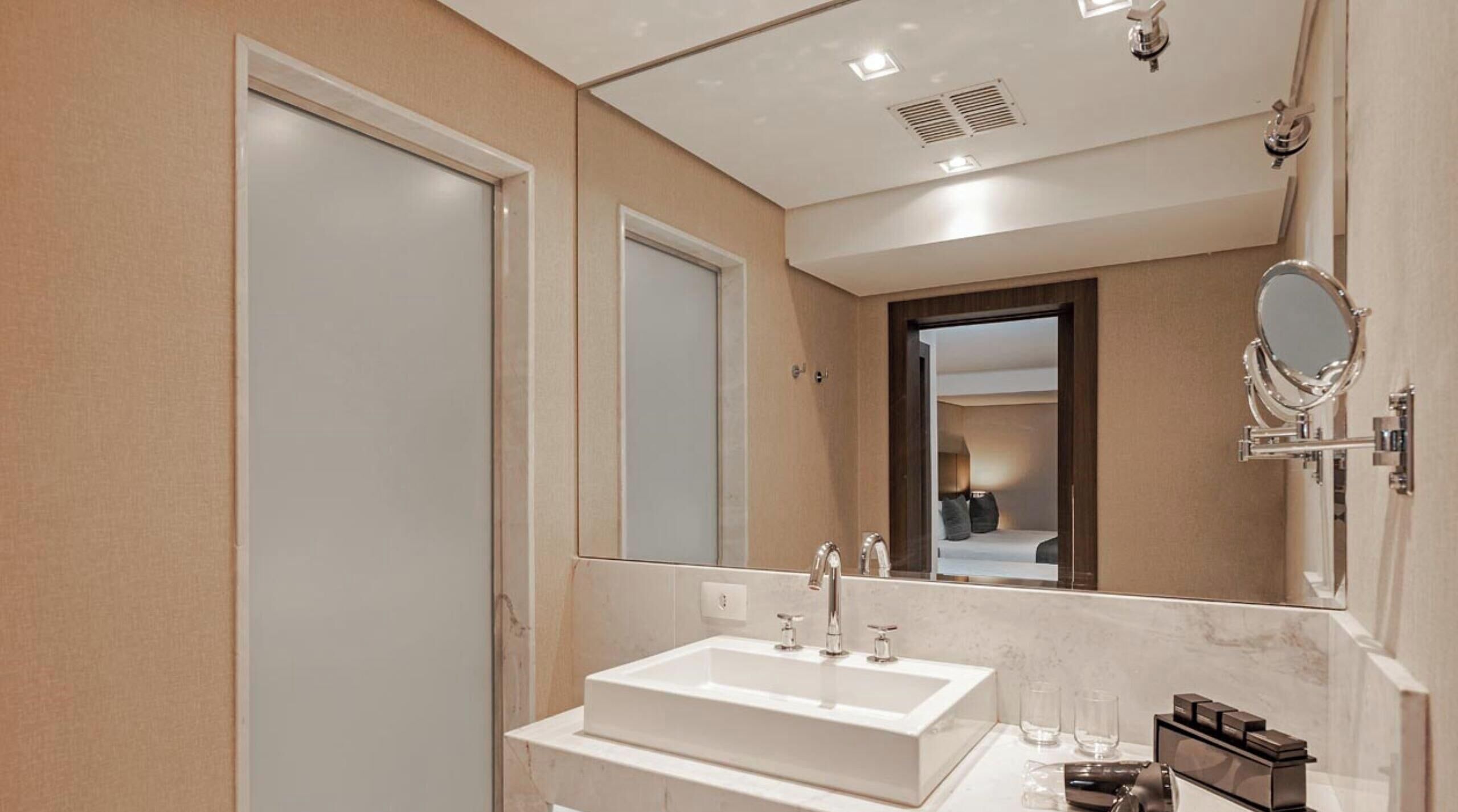 Une salle de bain moderne avec un double vasque, un grand miroir et une douche.