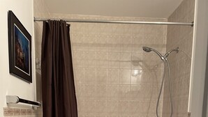 Une salle de bain équipée d’une baignoire, de toilettes, d’une douche et d’un porte-serviettes.