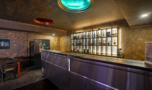 A bar area with a counter, shelves of liquor bottles, and a sign encouraging water conservation. - Treebo Seagate (Kanayannur)