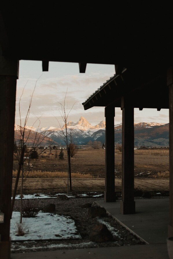 A covered outdoor area with a view of snow-capped mountains in the background.