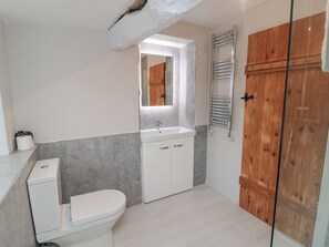 Une salle de bain avec des toilettes, un lavabo et une porte en bois.