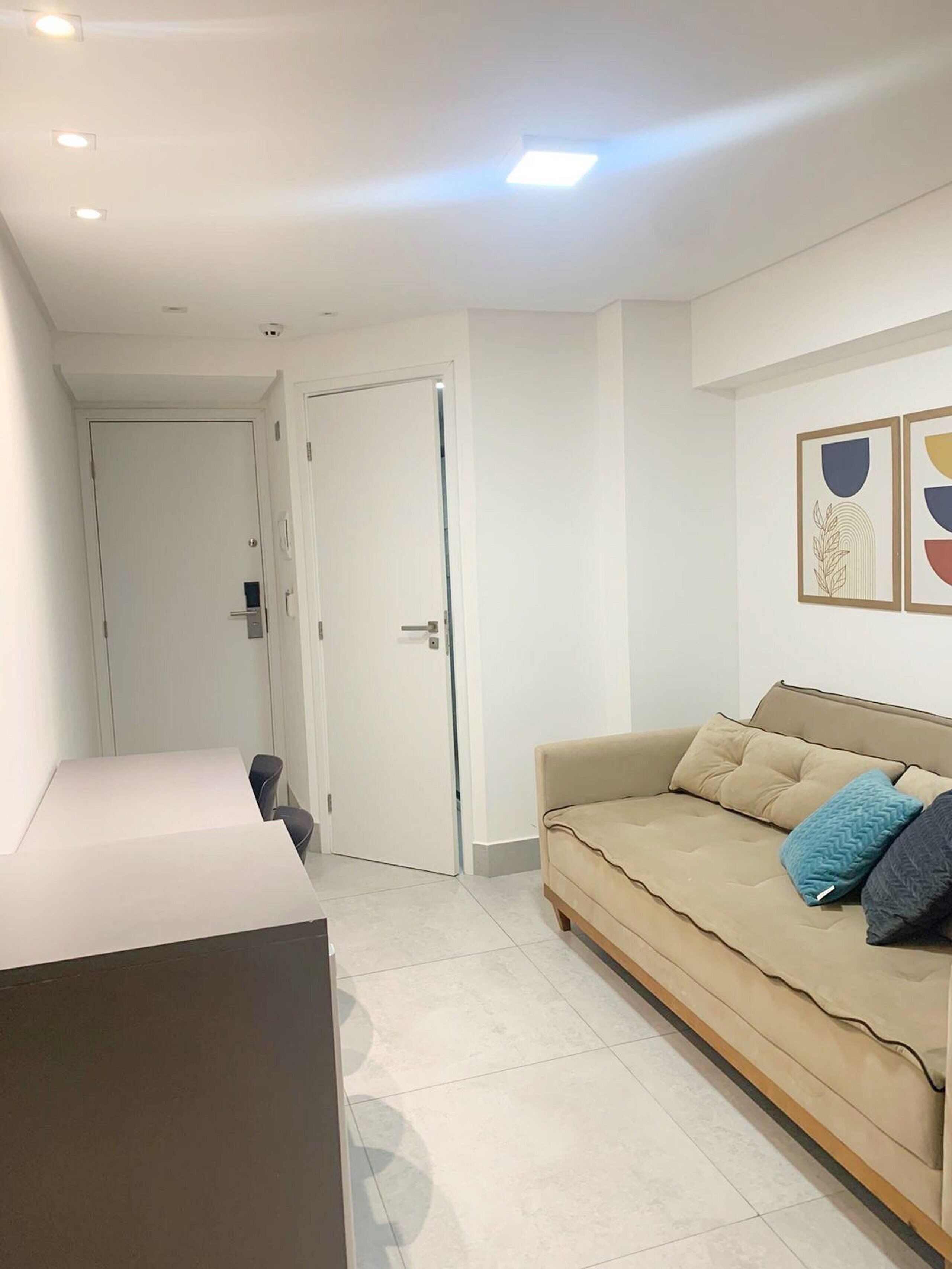 Une chambre moderne équipée d’un canapé, d’un bureau et d’une porte donnant sur une autre pièce.
