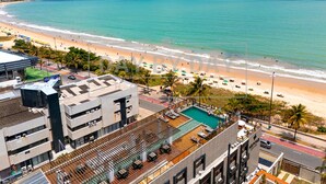 A hotel with a rooftop pool, a beach view, and a parking area. - Arpoar Suites By Day By Day (João Pessoa)