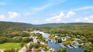 Une ville riveraine dotée d’un port de plaisance, entourée de collines et de verdure.