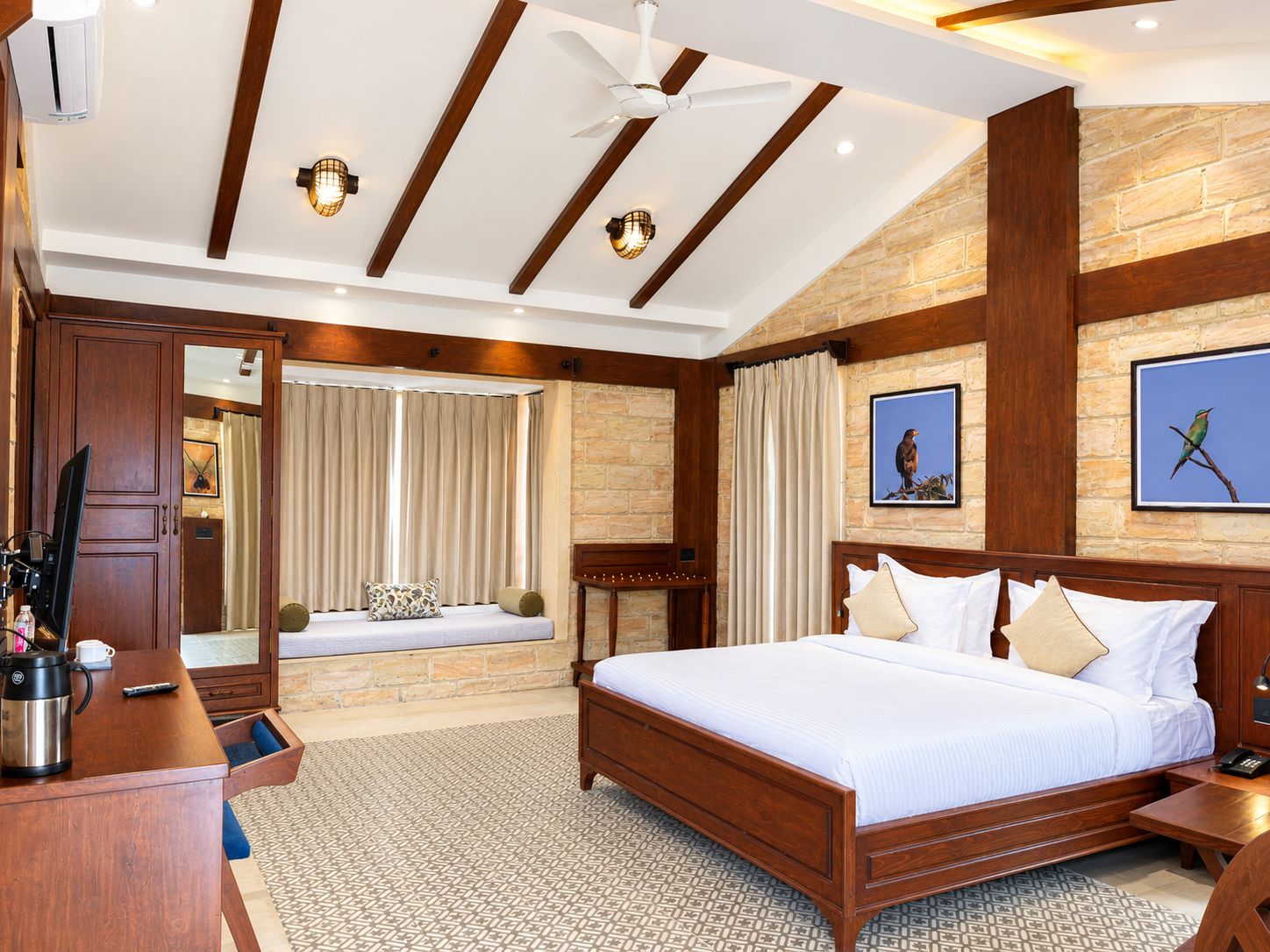 Habitación de hotel con una cama grande, un escritorio, una cafetera y vista al baño.